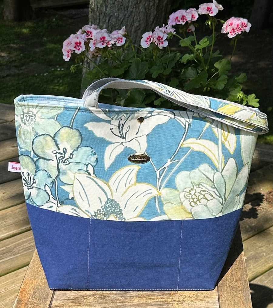 Fleur tote bag front with floral print and blue base.