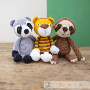 Crocheted raccoon, tiger, and sloth toys.