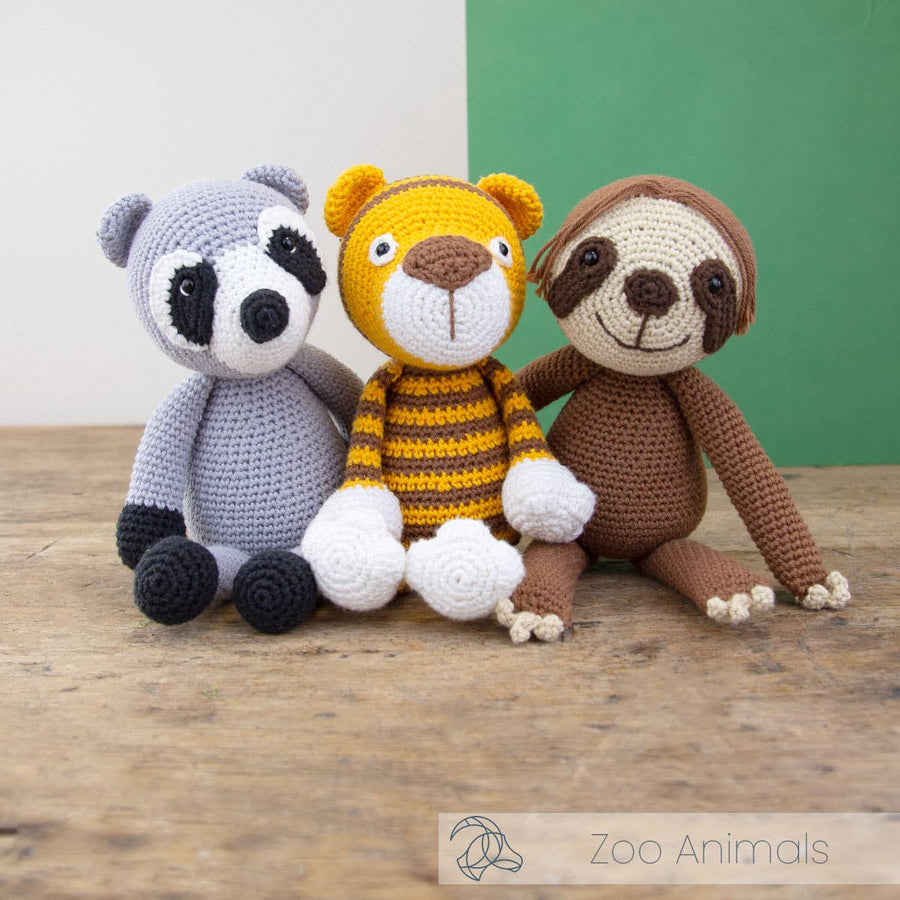 Crocheted raccoon, tiger, and sloth toys.
