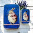 Load image into Gallery viewer, Notions Tin Firefly Notes featuring a plump bunny with a pink waistcoat on a vibrant blue background.

