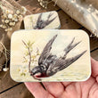 Load image into Gallery viewer, Notions Tin by Firefly Notes featuring a swallow in flight with cherry blossoms, vintage-style design.
