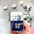 Load image into Gallery viewer, Notions Tin Firefly Notes featuring a tea set design with flowers, perfect for organizing stitch markers and needles.
