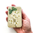 Load image into Gallery viewer, Notions Tin Firefly Notes displayed in hand featuring green moth and dogwood design on resin top.
