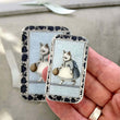 Load image into Gallery viewer, Notions Tin Firefly Notes featuring a whimsical illustration of a cat in vintage clothes, perfect for knitting and crocheting.
