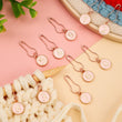 Load image into Gallery viewer, Set of numbered stitch markers for knitting and crochet, featuring numbers 0-9 with rose gold metal clasps.

