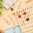 Load image into Gallery viewer, Numbered Stitch Markers for knitting and crochet in various colors on a cream knitted surface.
