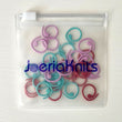 Load image into Gallery viewer, Spiral Stitch Markers in a clear pouch, featuring red, teal, and mauve colors for easy knitting organization.
