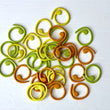 Load image into Gallery viewer, Spiral Stitch Markers in yellow, green, and orange colors, perfect for keeping track of stitches in knitting.
